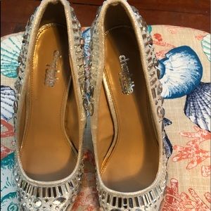 Woman silver dress shoes with rhinestone emblems.